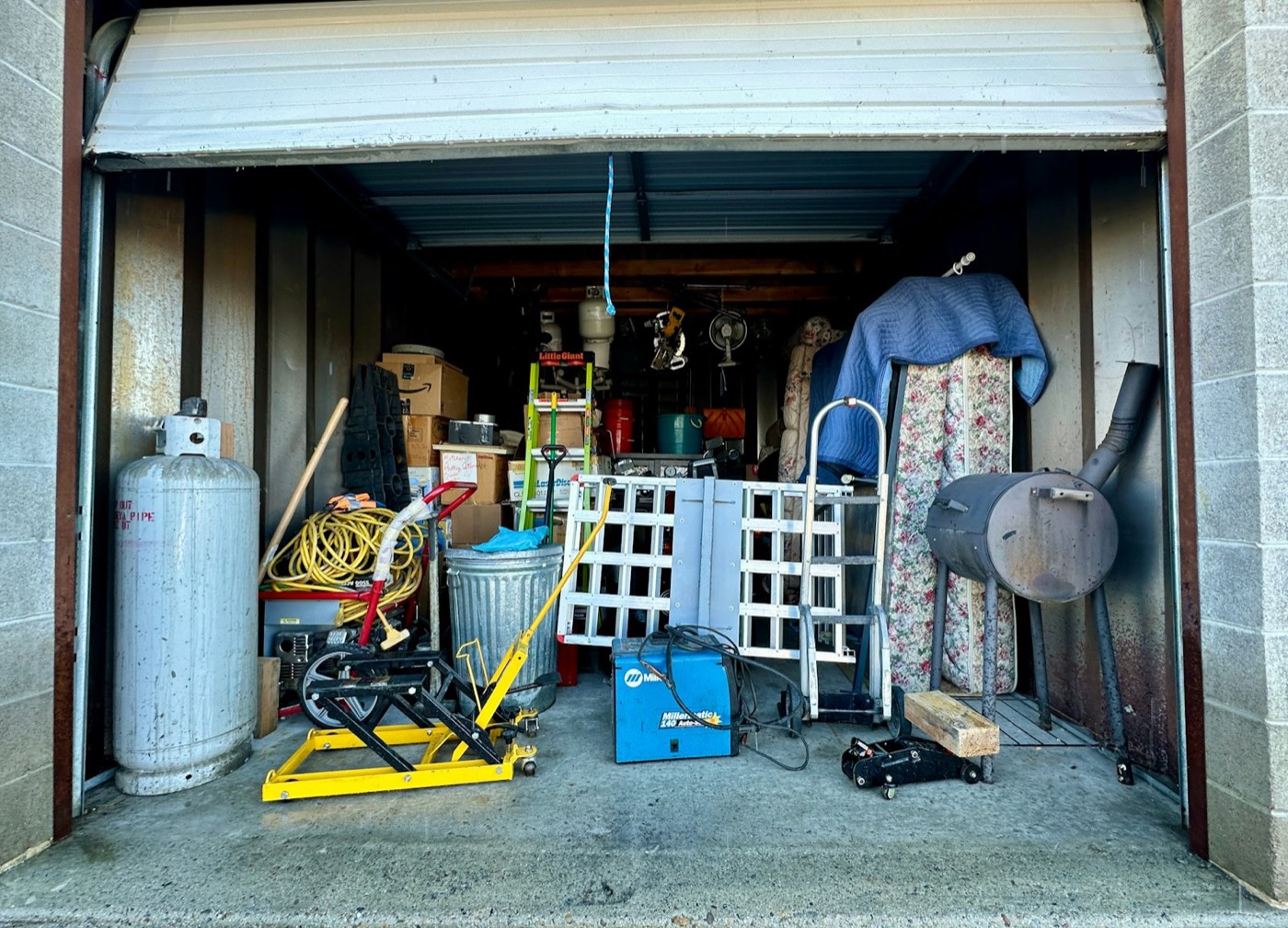 Garage packed with old equipment, tanks, and clutter
