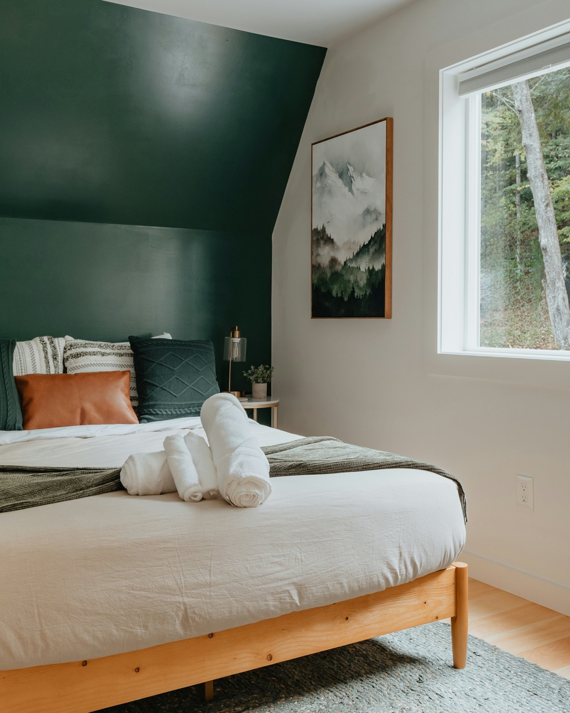Freshly made guest bed with rolled towels